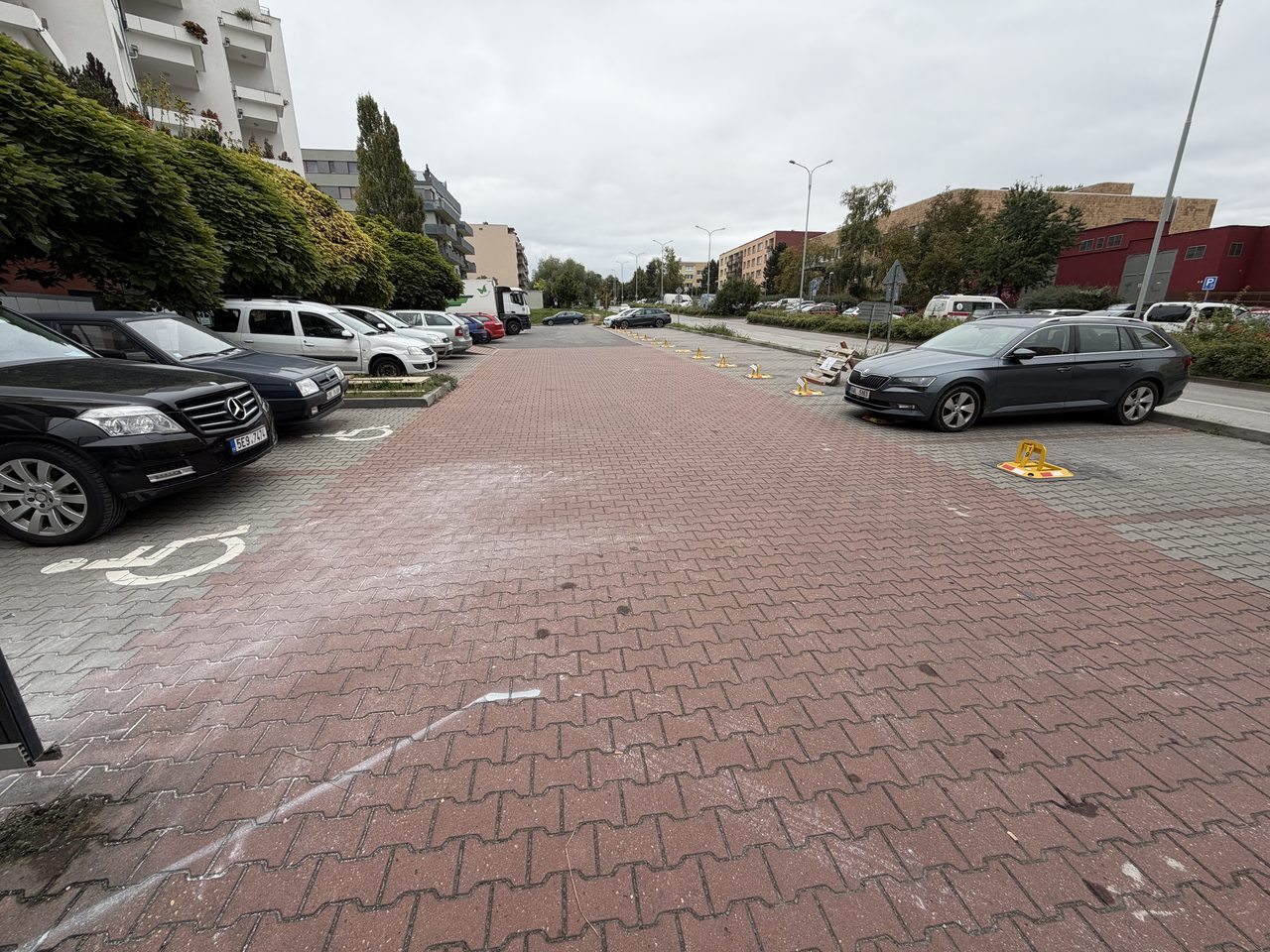 Parkoviště ve Štěpařské ulici v Praze 5 — zaparkovaná vozidla a žluté parkovací zábrany na volných místech